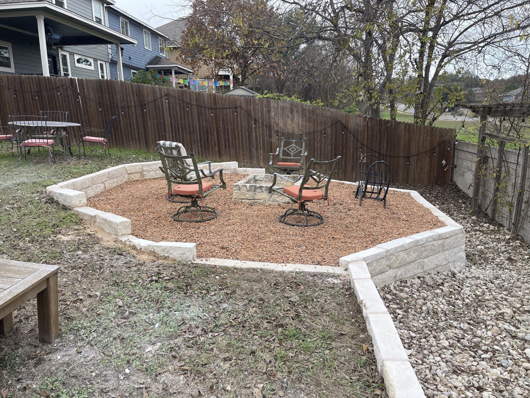 Finished gravel fire-pit seating area with limestone retaining walls