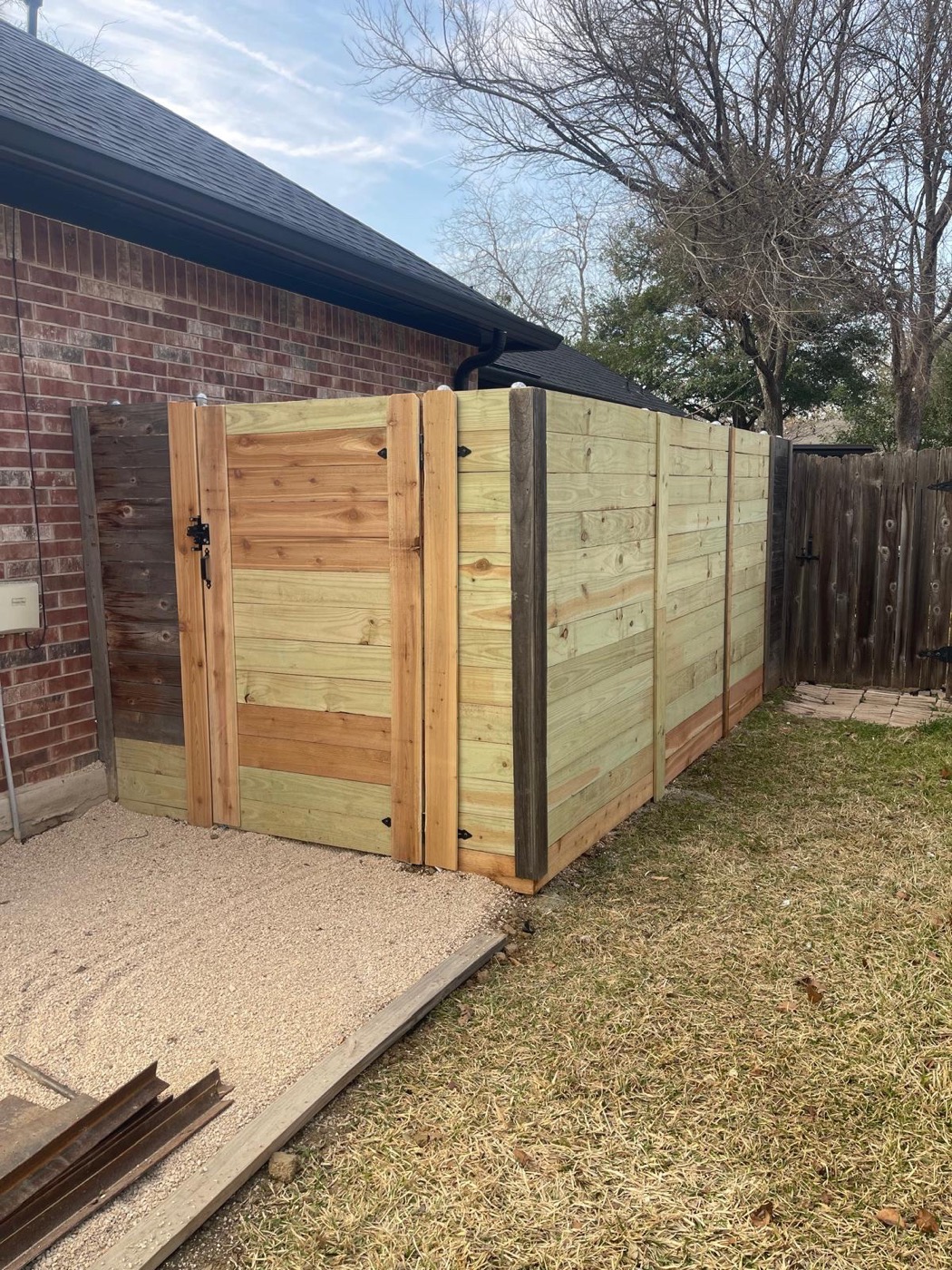 Completed horizontal-board utility enclosure with a framed gate