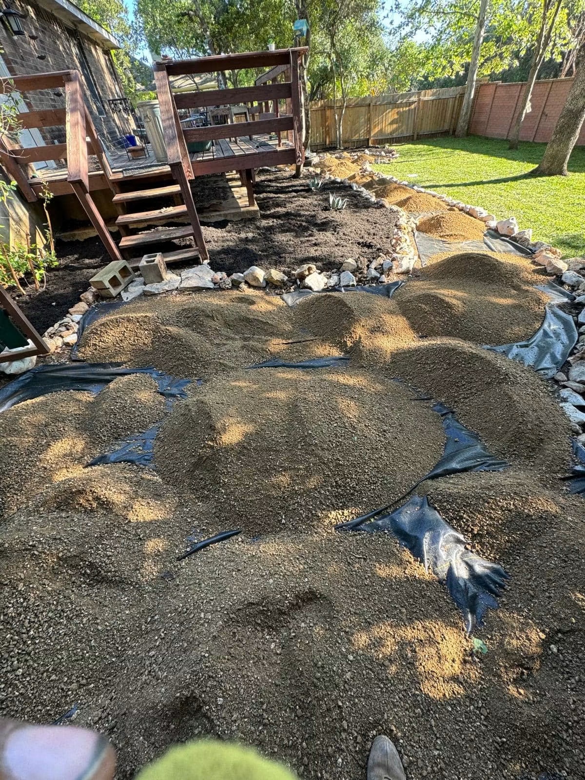 Gravel staged across landscape fabric during residential path construction